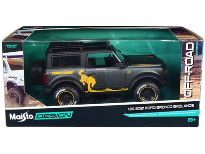 2021 Ford Bronco Badlands Dark Gray Metallic with Gold Graphics and Roof Rack "Off-Road" "Maisto Design" Series 1/24 Diecast Model Car by Maisto