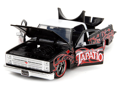 1985 Chevrolet C-10 Pickup Truck Black with White Top and Graphics with Charro Man Diecast Figure "Tapatio" 1/24 Diecast Model Car by Jada