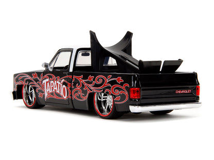 1985 Chevrolet C-10 Pickup Truck Black with White Top and Graphics with Charro Man Diecast Figure "Tapatio" 1/24 Diecast Model Car by Jada